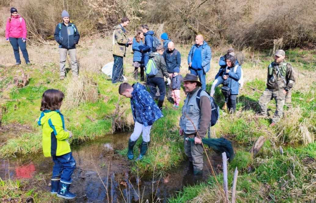 Účastníci vycházky se brodí v mokřadu.