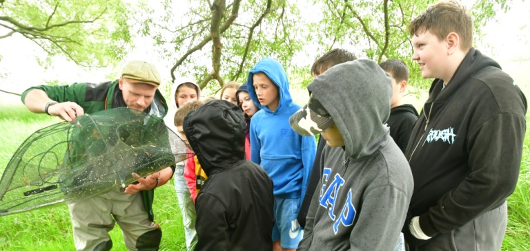 Žáci ZŠ Sokoleč si prohlížejí úlovek.